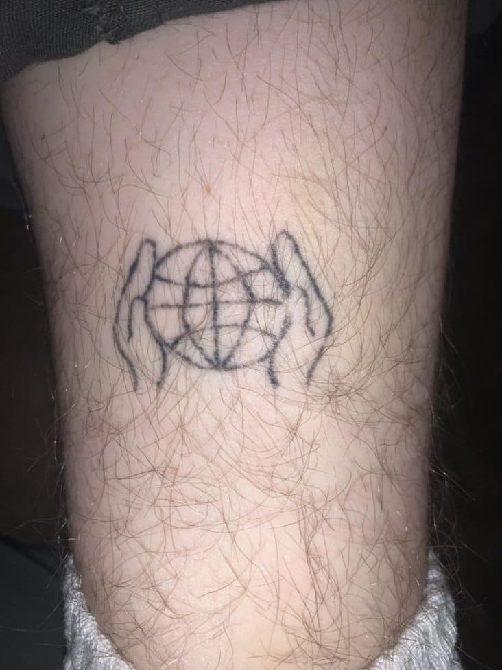 hands holding globe tattoo