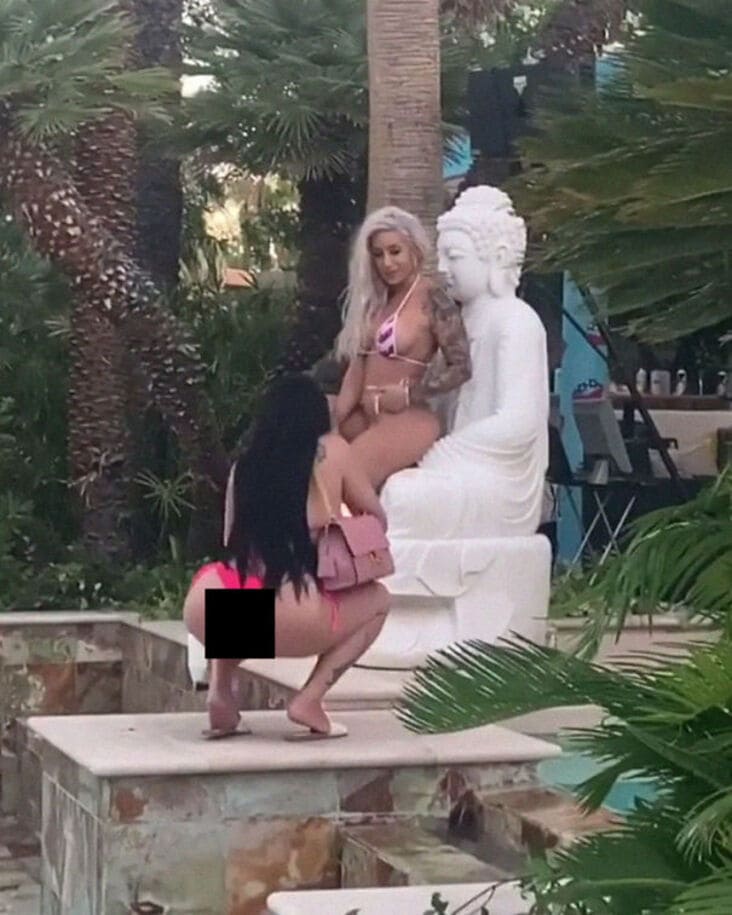 woman sitting on what appears to be buddha statue influencer in the wild, sitting on what appears to be buddha statue influencer fail