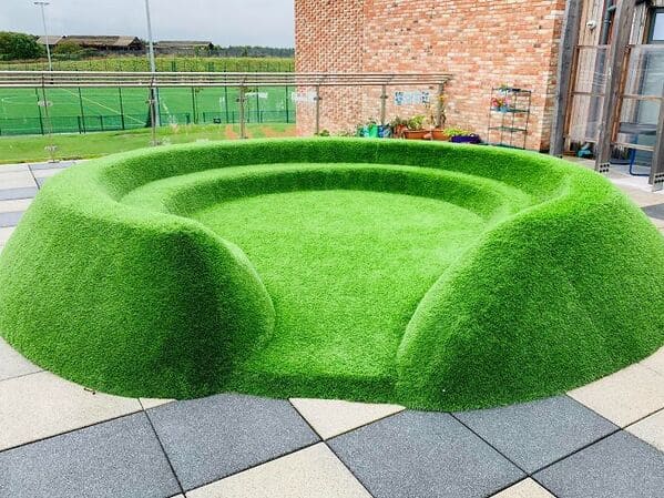 glitch in the matrix images - Artificial Grass Seating Looks Like It Was Rendered In Badly To The Scenery