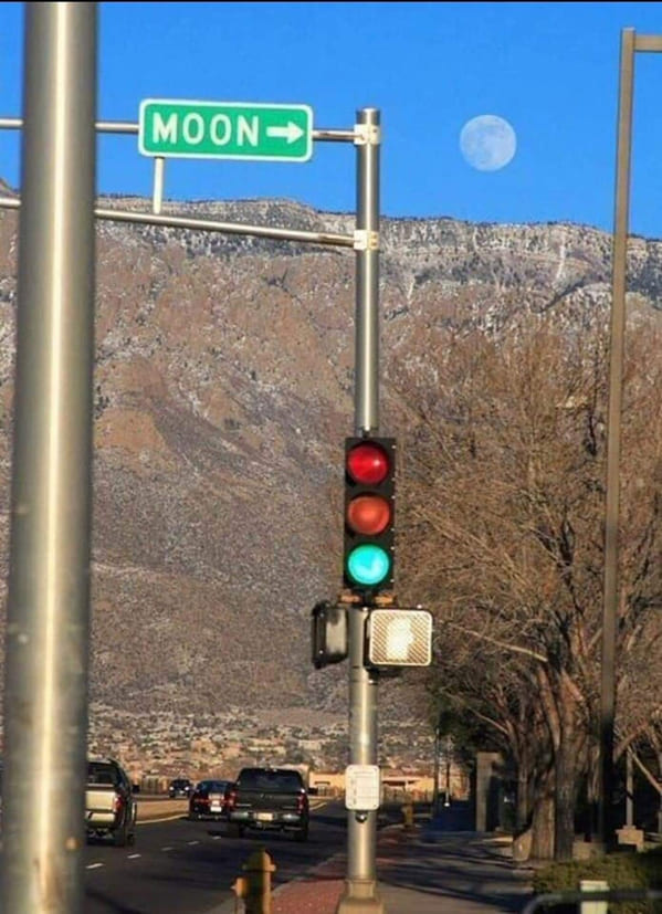 accidental surrealism - moon street sign pointing at moon