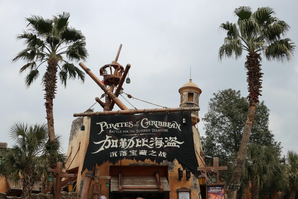 a sign for pirates of the carriben with palm trees in the background