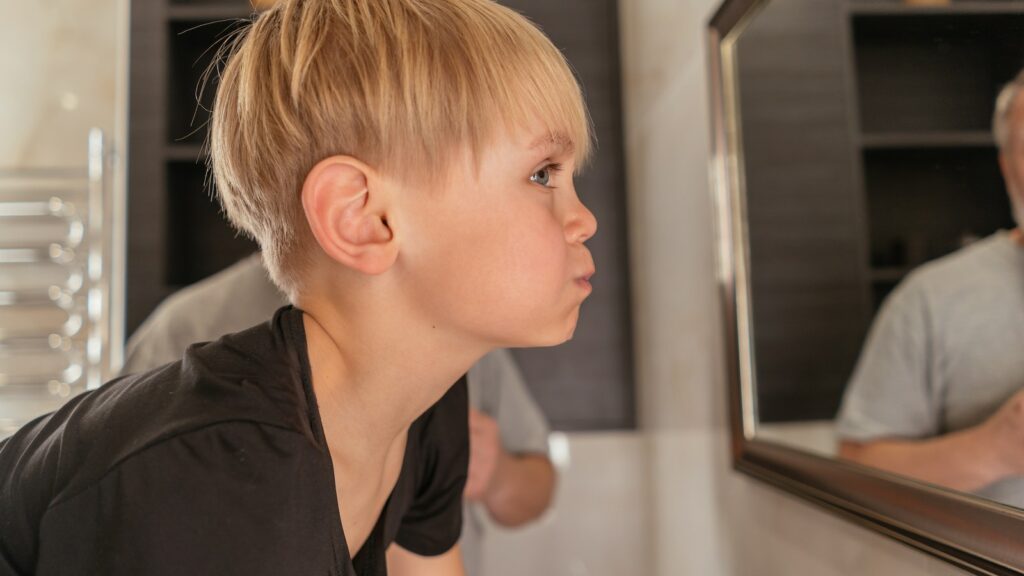Boy in Black Shirt Looking at the Mirror
