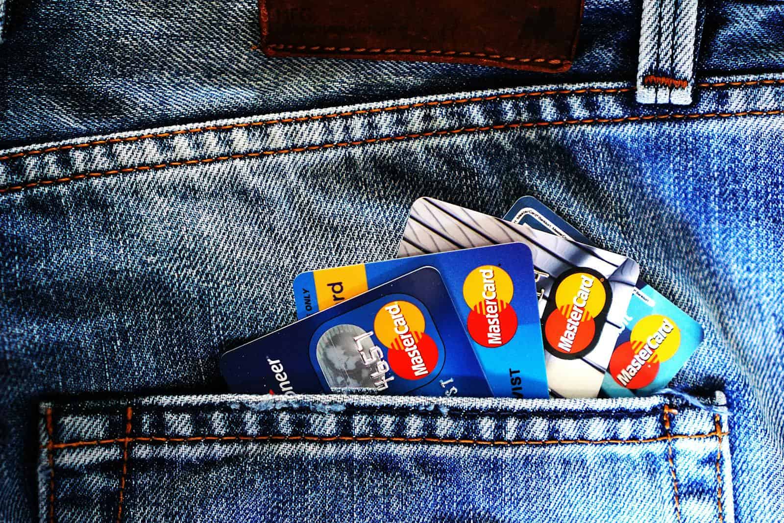 Close-up of a denim pocket with multiple credit cards, illustrating finance and fashion.