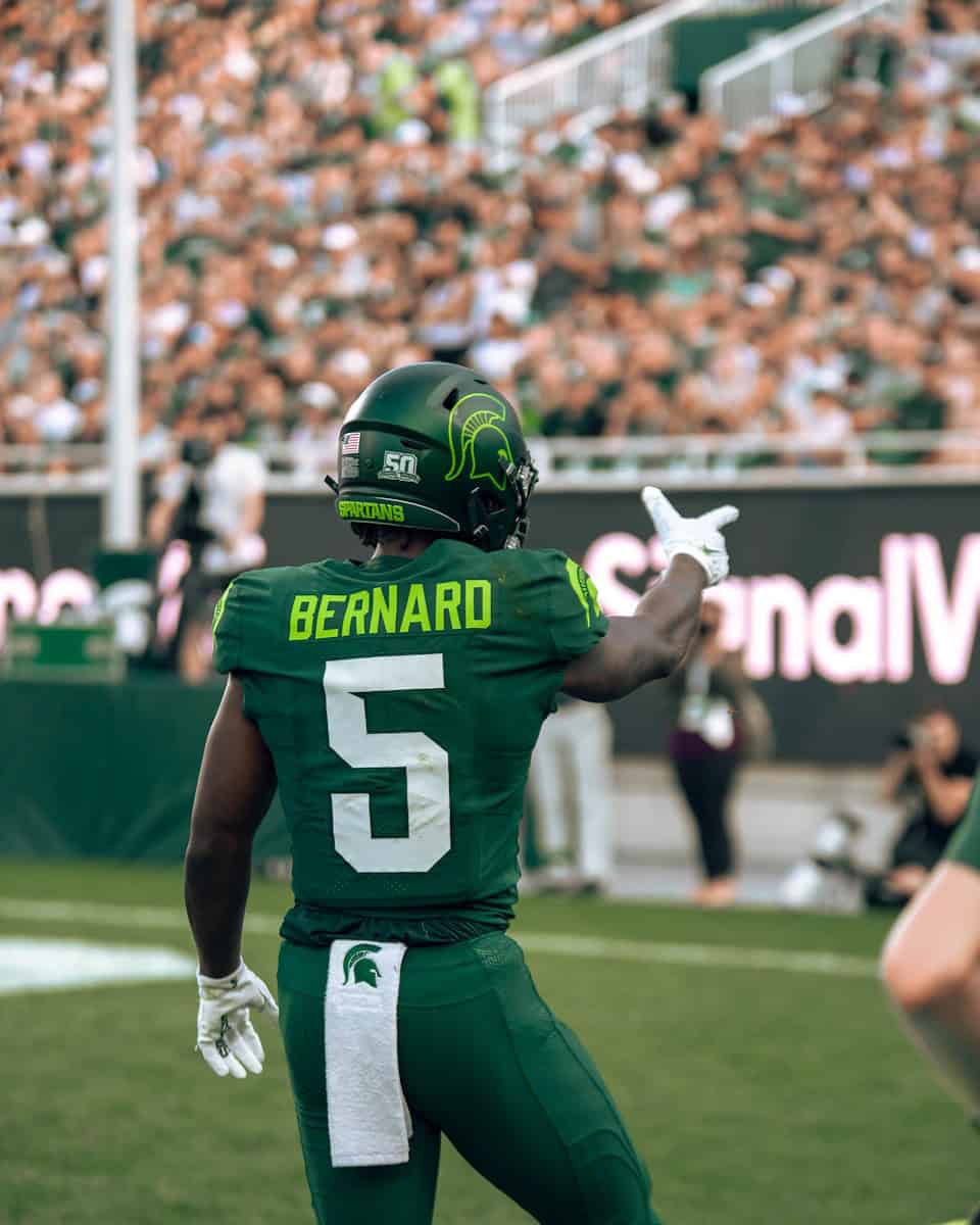 A football player in a green uniform on the field