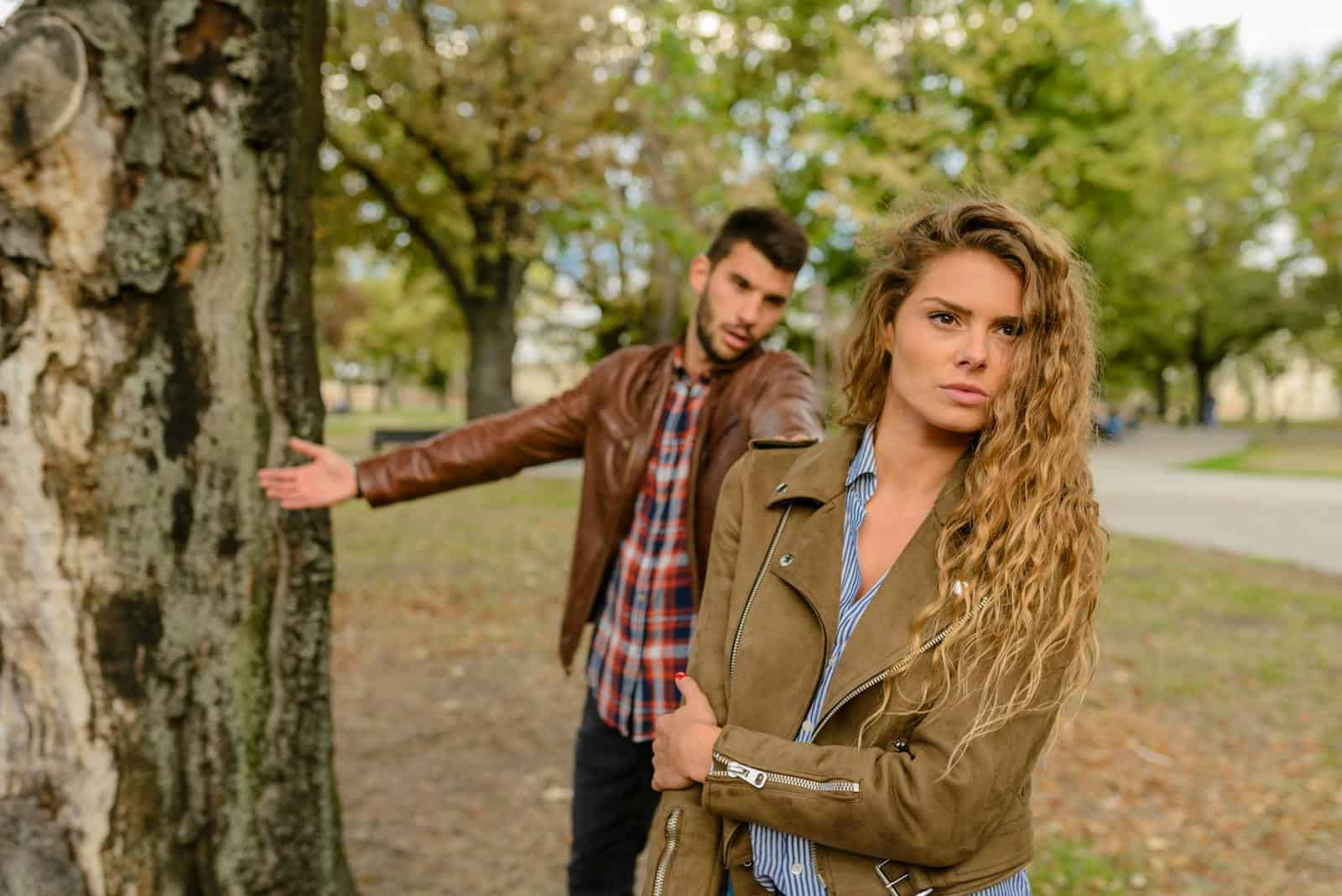 A man and woman in a heated argument outdoors, expressing emotions.