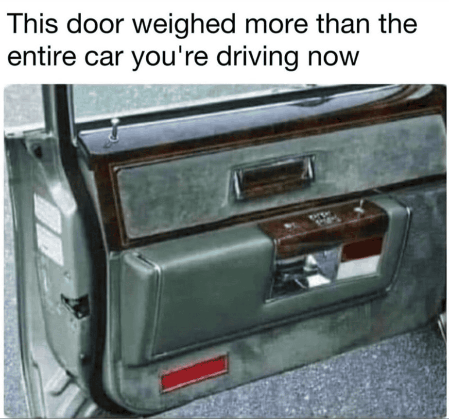 Vintage car door with a large, heavy door panel and wood trim.