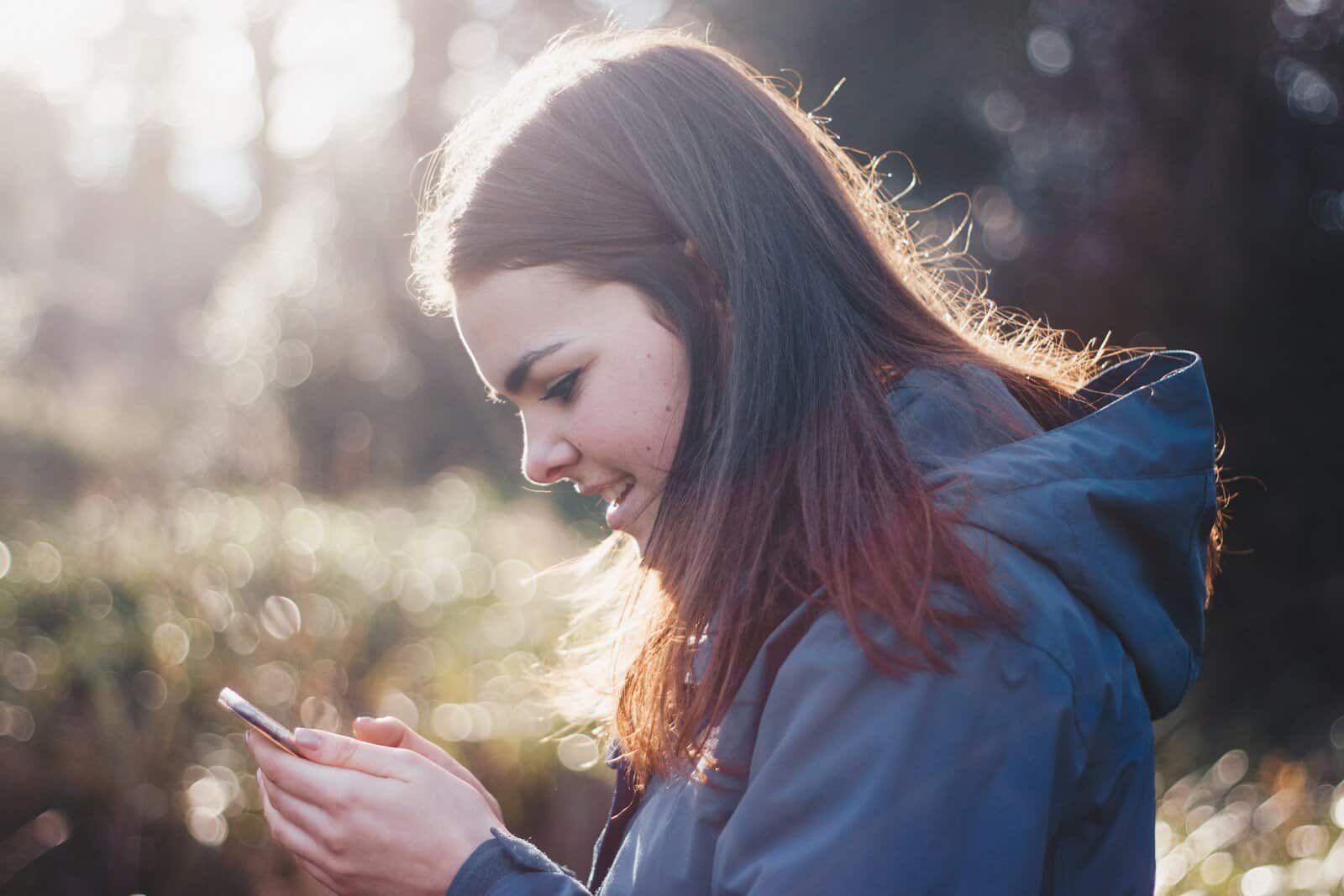 Femme tenant le téléphone souriant