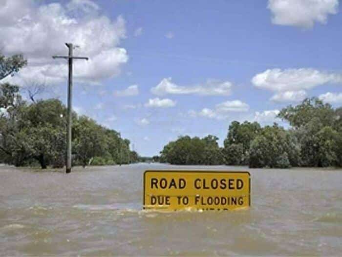 A road closed due to flooding sign in flood water.
