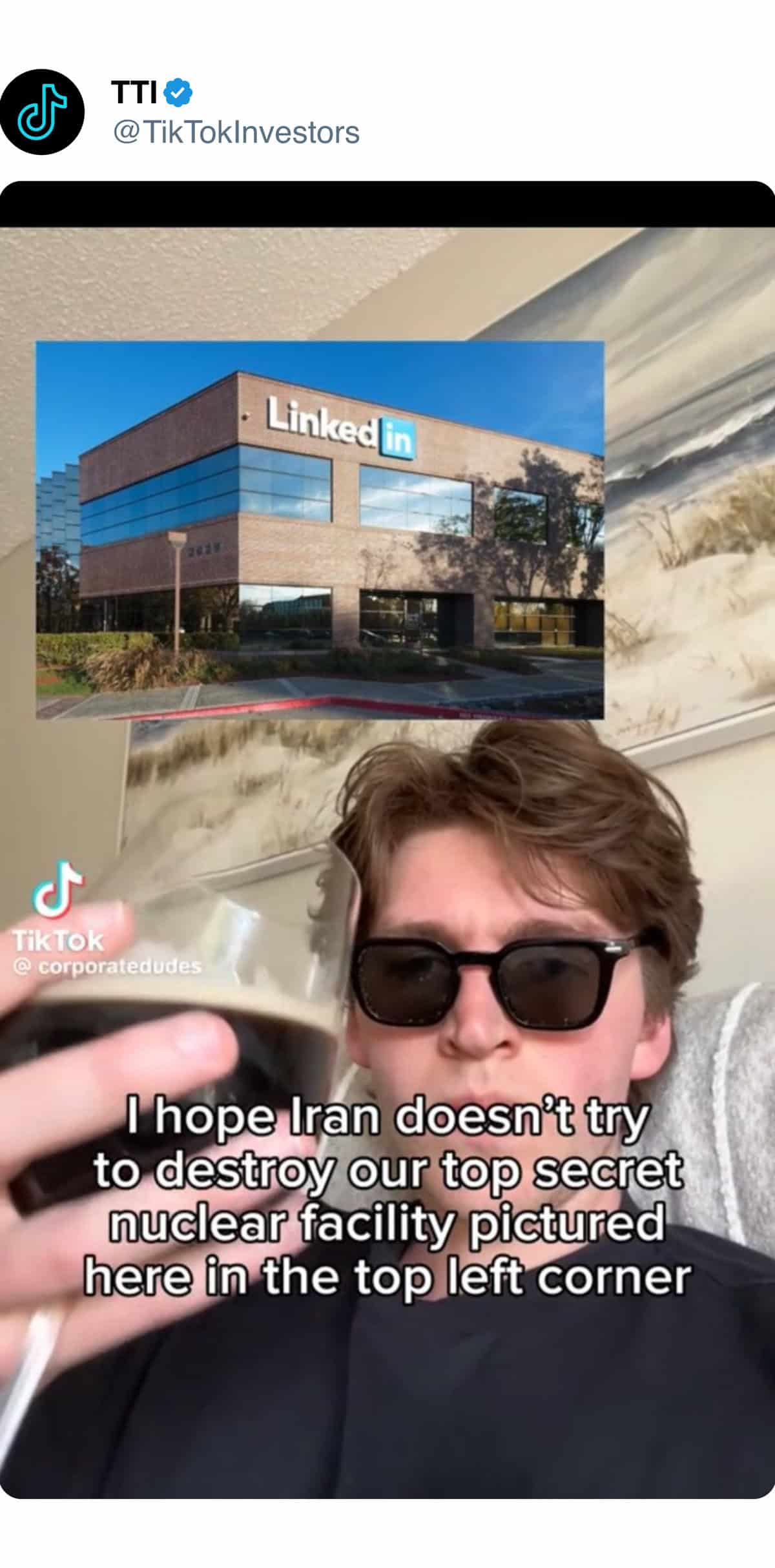 A man with sunglasses and a glass of wine is holding a phone.