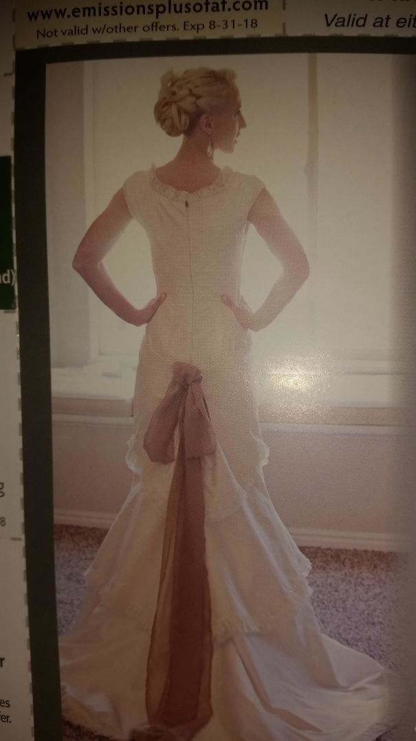 Wedding dress with bow detail and elegant updo hairstyle.