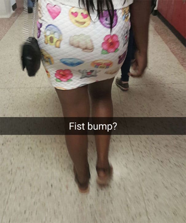Woman in emoji-patterned dress walking in a store, showing her legs and footwear.