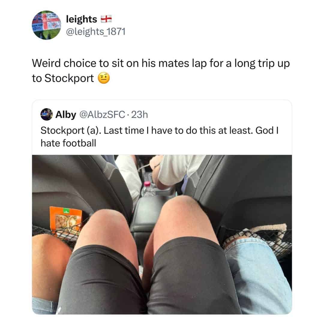 Person sitting on a friend's lap during a flight, showing their legs and shorts.