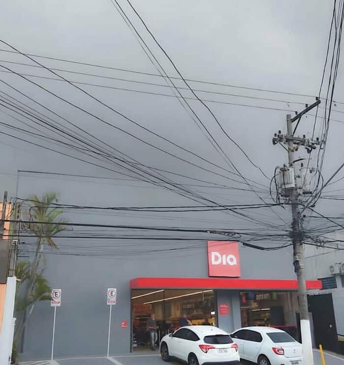 View of Pleated Jeans store with power lines and stormy sky in the background.
