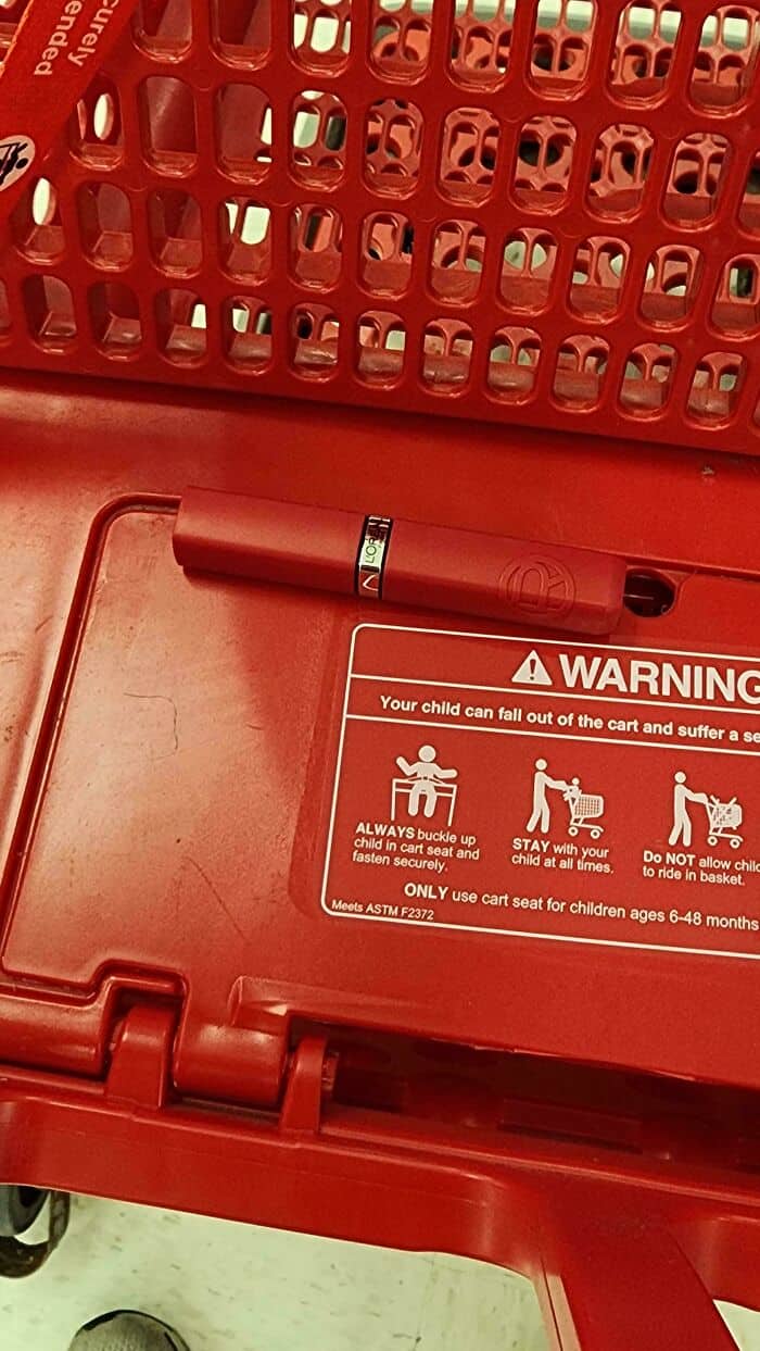 Shopping cart with warning sticker and pen for customer use.