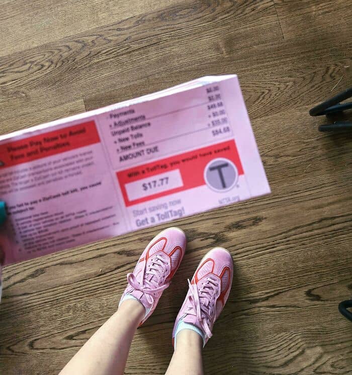Close-up of pink running shoes on wooden floor with receipt.