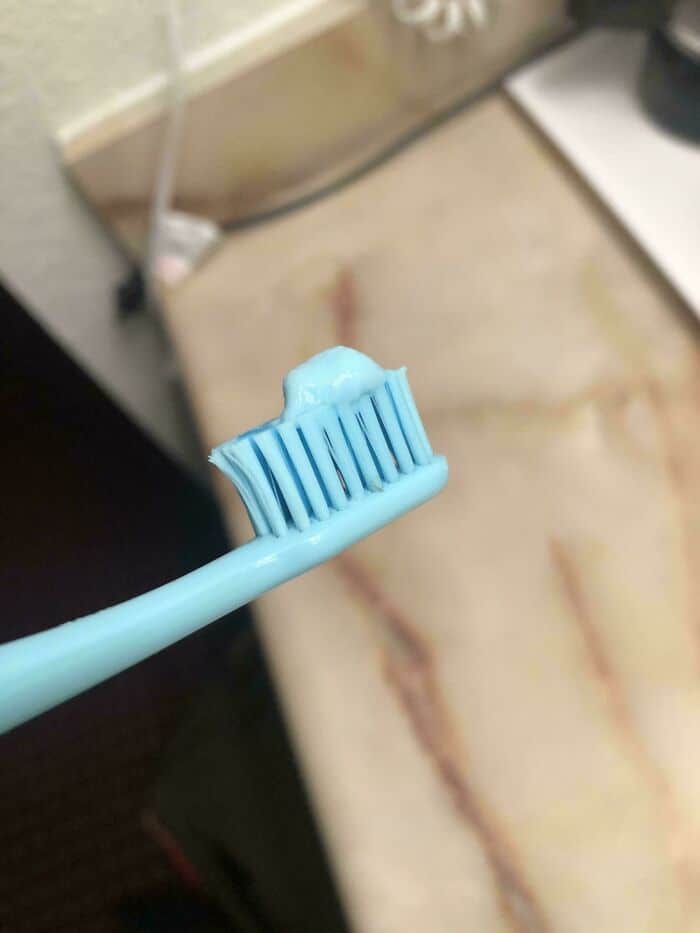 Toothbrush with blue toothpaste, dental hygiene, oral care, close-up image.