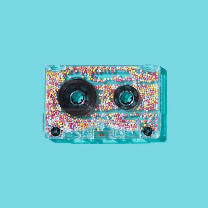 Vintage cassette tape with multicolored beads inside, blending surrealism and playful design.