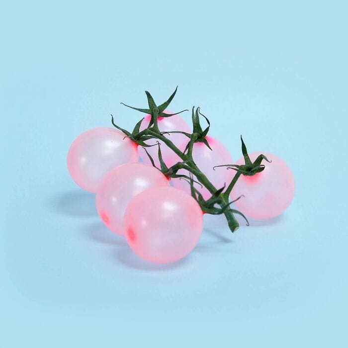 Tomato cluster with pink-illuminated tomatoes on a light blue background, blending surrealism and pl.