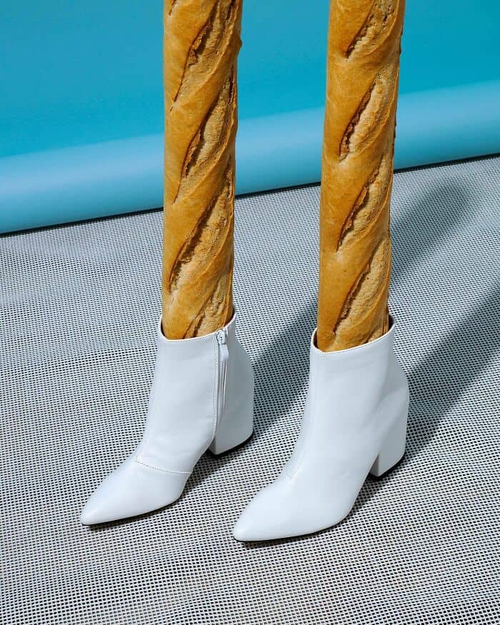 Whimsical shoes with breadstick legs and white high heels, blending surrealism and humor.