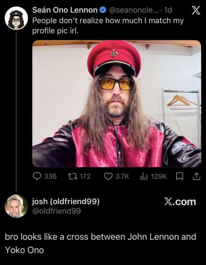 Seán Ono Lennon wearing a pink hat and jacket, yellow glasses, with long hair and beard.