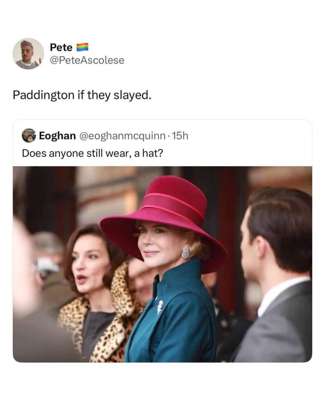 Woman in red hat and teal coat at a social event.