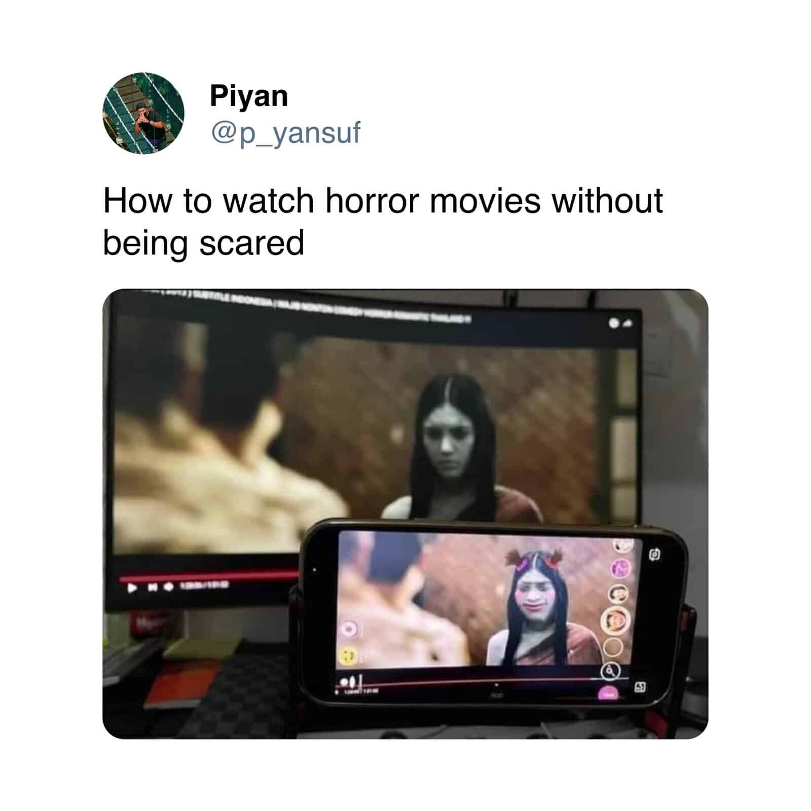 Person watching horror movie on TV and phone for fear-free viewing.