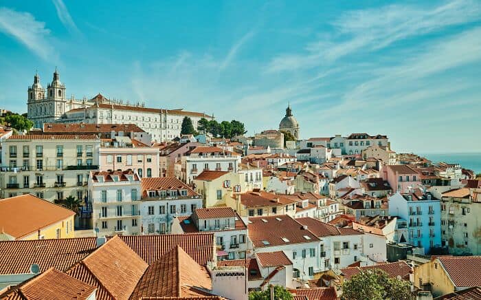 Vibrant cityscape of Lisbon featuring colorful buildings, historic architecture, and a clear blue sk.