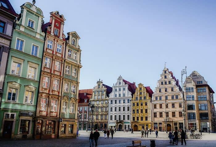 Vibrant row of colorful historic buildings in a European city square, bustling with pedestrians and.