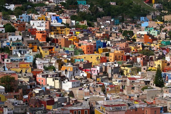 Vibrant colorful houses in a hillside cityscape, showcasing Mexico City's lively urban environment.