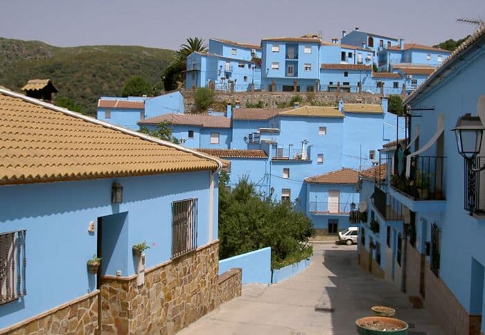 Blue-painted houses in a vibrant hillside cityscape, showcasing colorful urban architecture and scen.