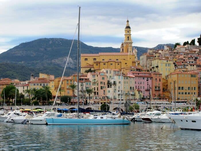 Vibrant city harbor with colorful buildings, boats, and hillside scenery, perfect for travel and urb.