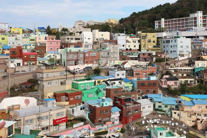 Colorful hillside cityscape with vibrant houses and buildings, reflecting a lively urban environment.