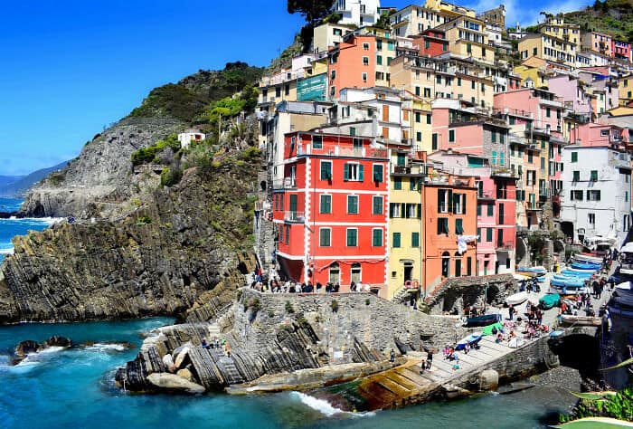 Vibrant seaside town with colorful houses on rugged cliffs, Mediterranean setting.