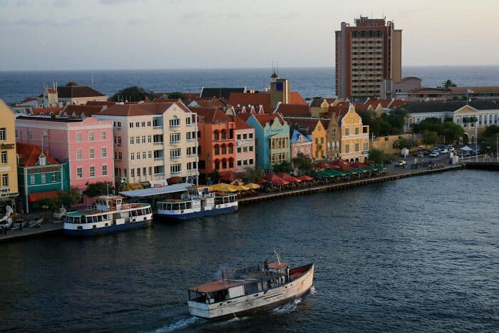 Vibrant colorful cityscape with waterfront buildings and boats in the harbor, perfect for urban trav.