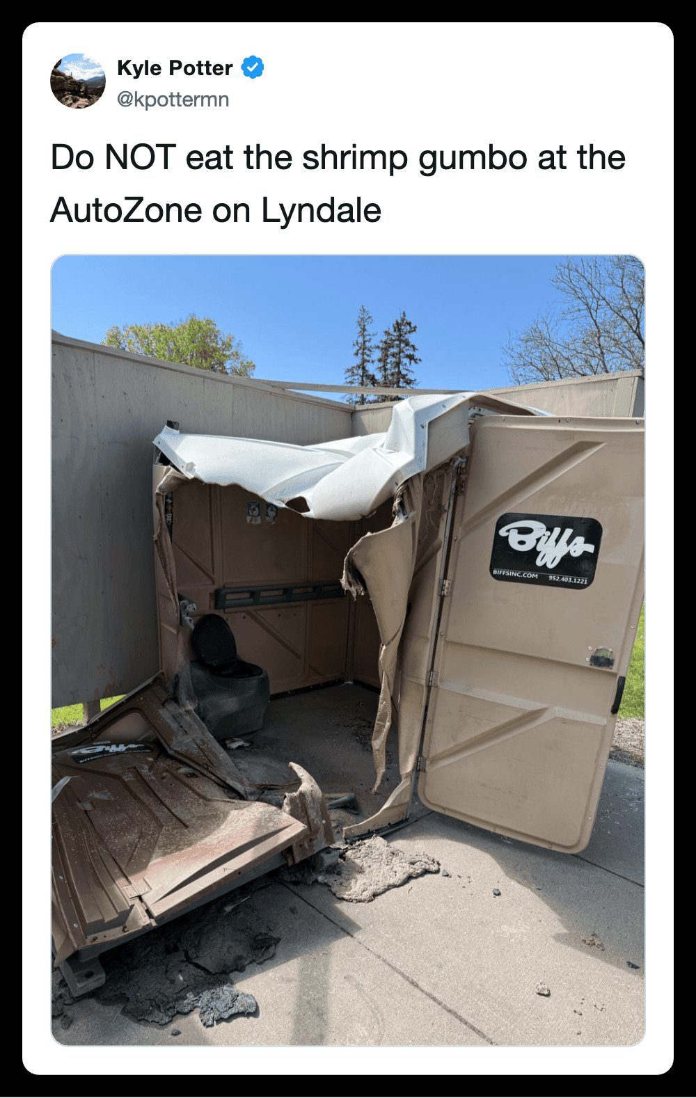 Damaged AutoZone trash bin after accident, with torn lid and debris.