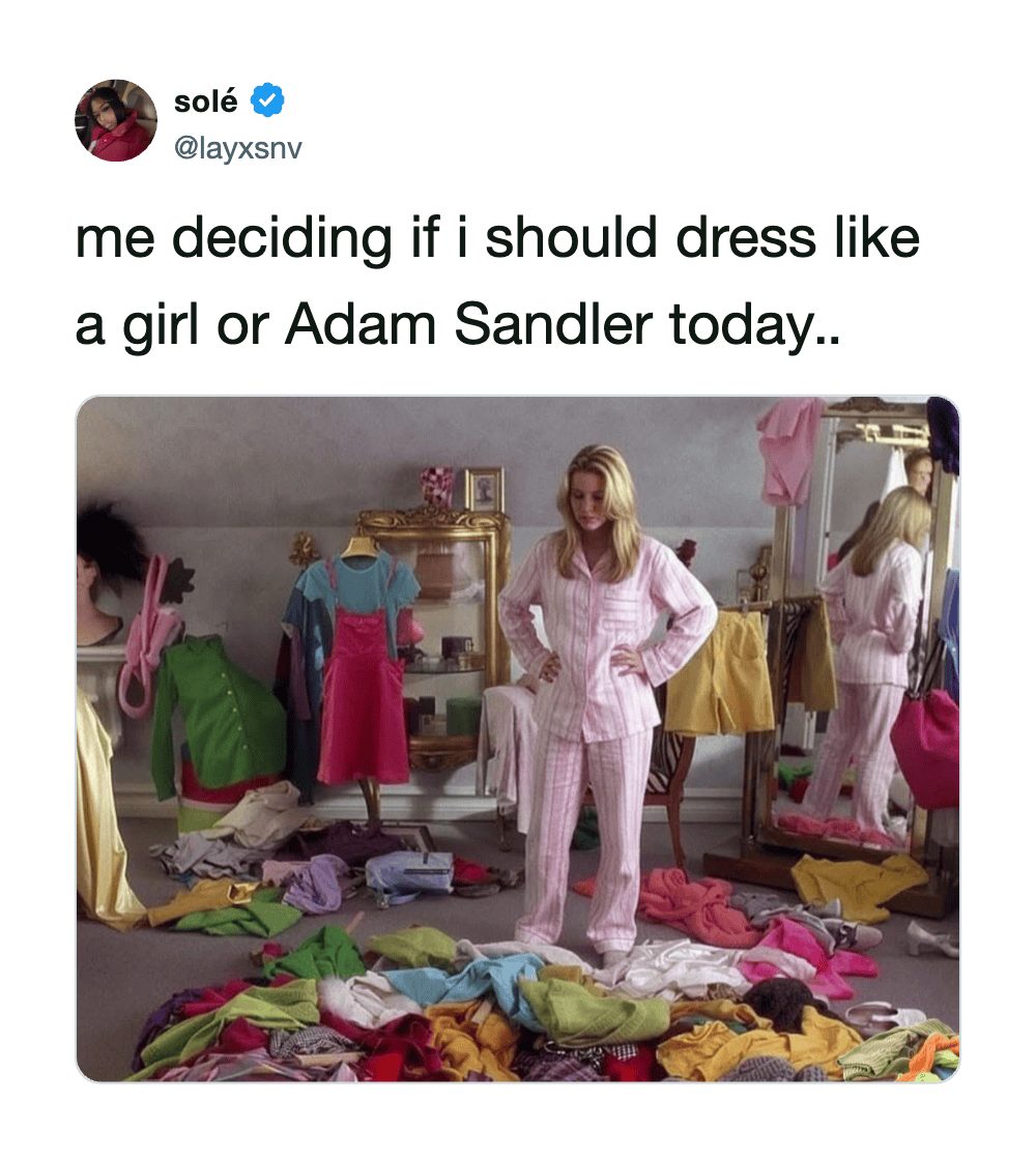 Woman in pink and white striped pajamas surrounded by colorful clothes in a dressing room.