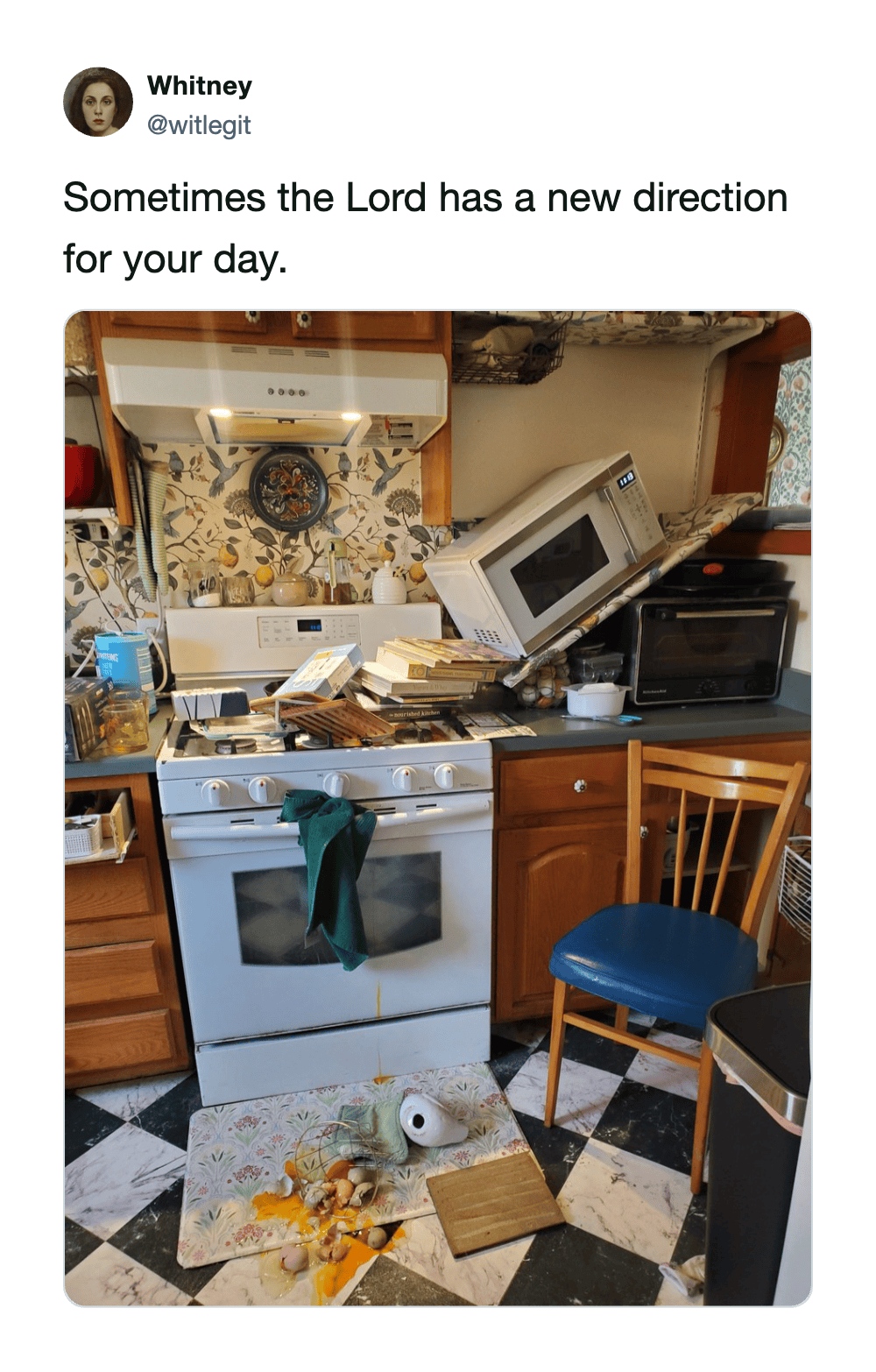 Disorganized kitchen scene with stove, microwave, and scattered supplies on checkered floor.