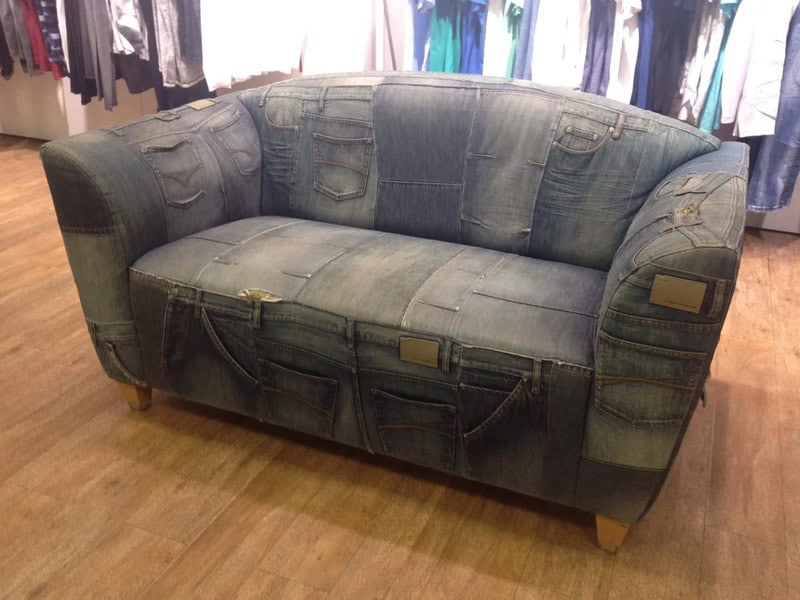 Vintage denim patchwork sofa with wooden legs for a unique, rustic look.