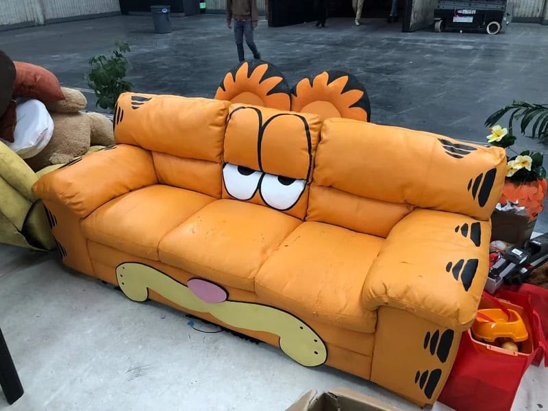 Plush Garfield sofa with cartoon eyes and orange fur design, perfect for children's rooms or comic f.