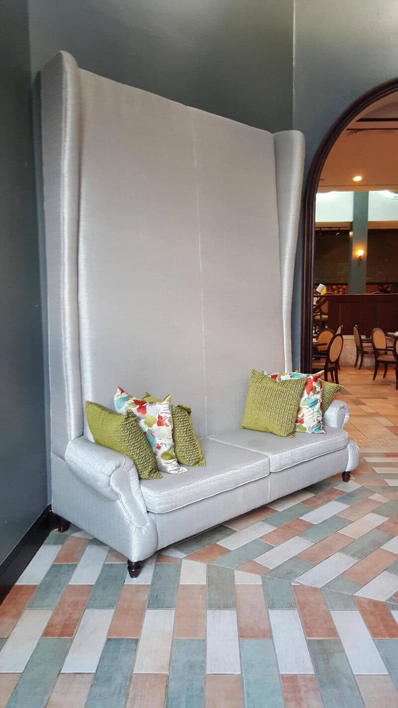 High-back upholstered booth with decorative pillows in a modern restaurant interior.