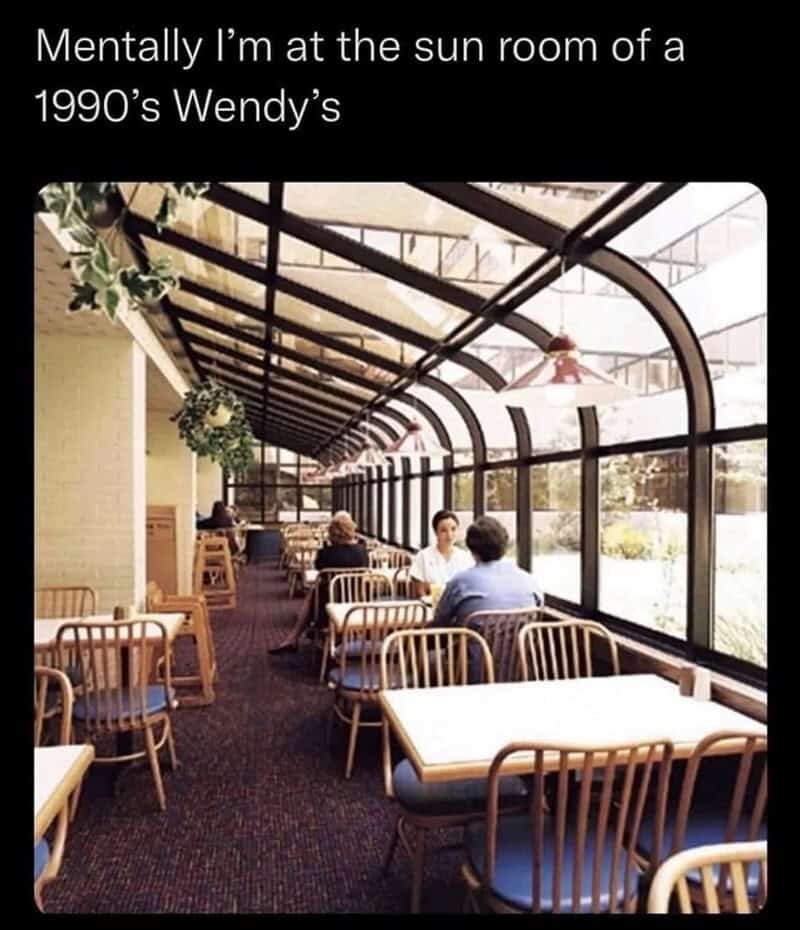Sunroom of a 1990s Wendy's restaurant with patrons dining and relaxing.