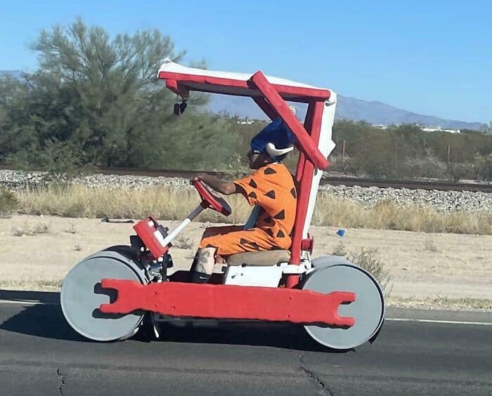 Wholesome funny men costume in a DIY vehicle, perfect for family fun and outdoor entertainment.