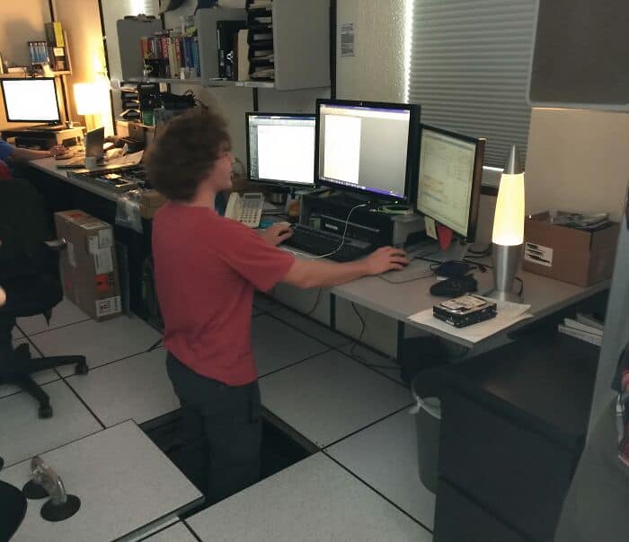 Workstation with multiple monitors and a person working at a desk.