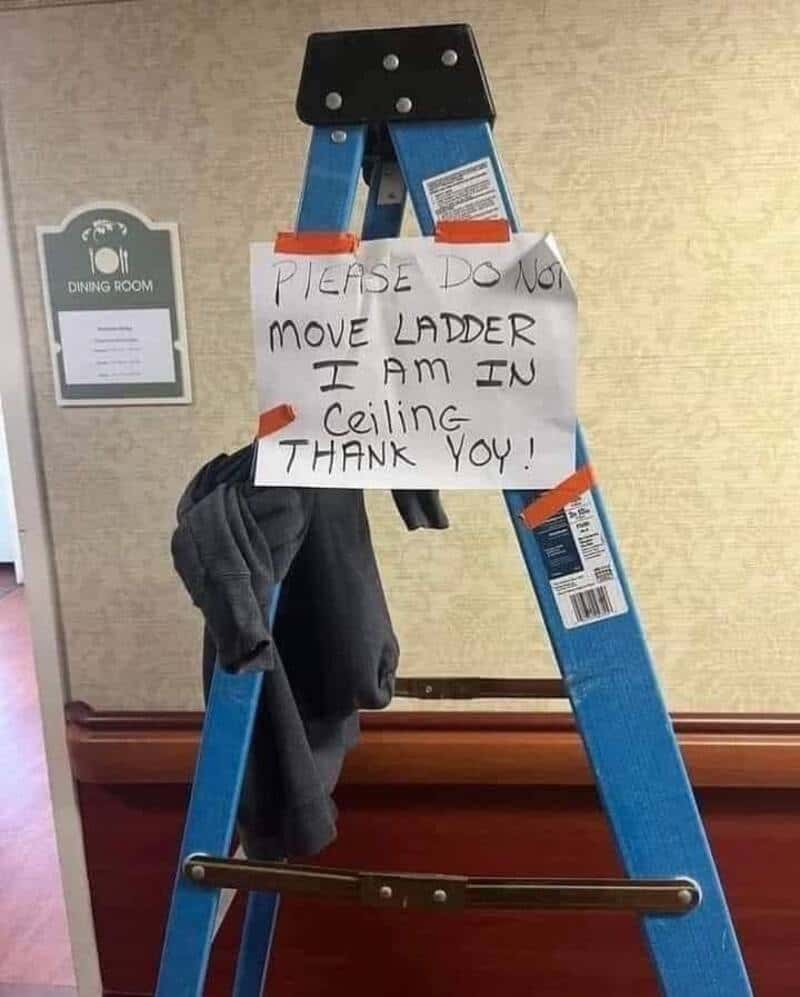 Ladder with a handwritten sign requesting to not move it, placed in a ceiling area.
