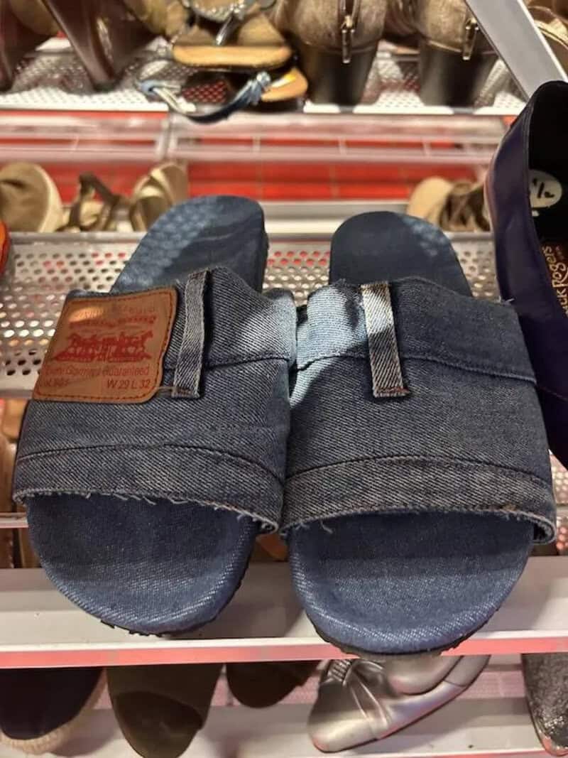 Denim sandals with rolled-up cuffs, displayed on store shelf.