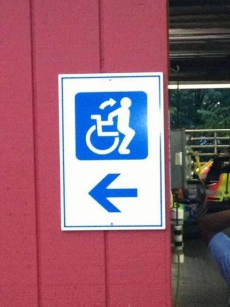 Accessible parking sign with wheelchair symbol and arrow pointing left.