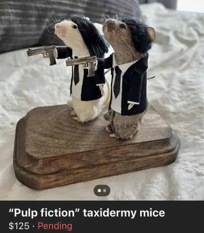 Cute taxidermy mice dressed as "Pulp Fiction" characters with guns on a wooden base.