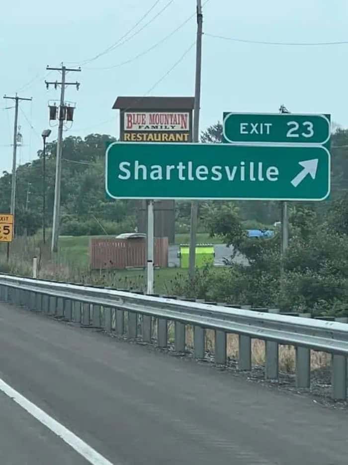 Exit 23 to Shartlesville on highway with restaurant sign in background.