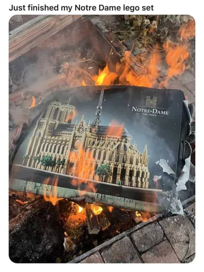 Burning Notre Dame Lego set on fire outdoors with flames and smoke.