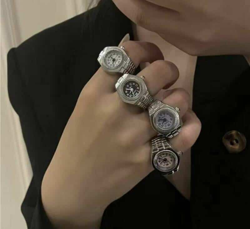 Multiple watches stacked on fingers, creating a humorous and unusual accessory.